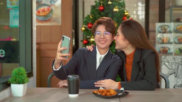 Young adult lesbian couple taking selfie with smartphone, LGBT Pride Month, Gay Pride Symbol.