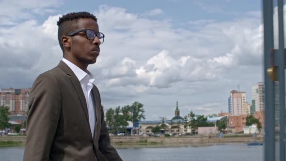 Successful Businessman Walking along Riverside