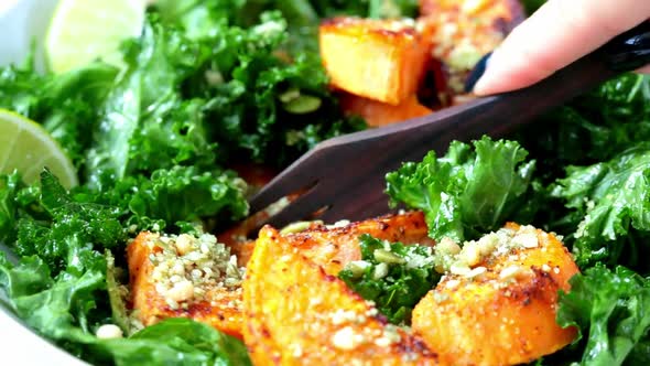 Baked sweet potato salad with kale in white bowl.