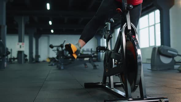 Closeup Legs of Group Unrecognizable Friends at Gym Exercising on Stationary Bike at Class in Gym