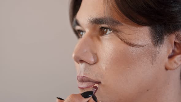 Makeup Studio - Makeup Artist Applying Red Lip Pencil on the Lips of Male Model