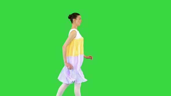 Young Beautiful Girl in Whiteyellow Dress Runs Seemingly Happy on a Green Screen Chroma Key