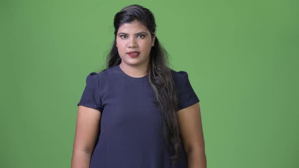 Young Overweight Beautiful Indian Businesswoman Against Green Background