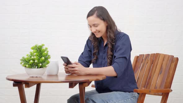 Happy Indian girl using phone