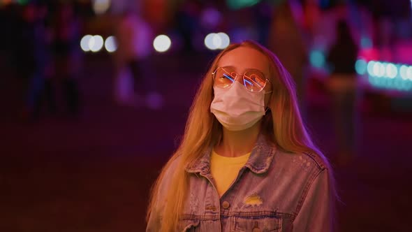 Young Woman in Surgical Face Mask Social Distancing at Amusement Park
