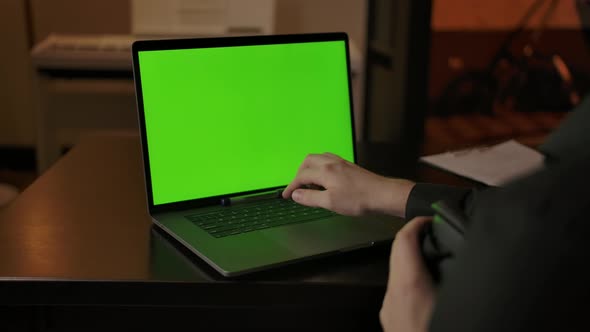 Caucasian Male Engineer with VR Helmet Typing on Laptop with Green Screen