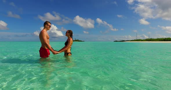 Happy boy and girl on romantic honeymoon spend quality time on beach on white sand 4K background