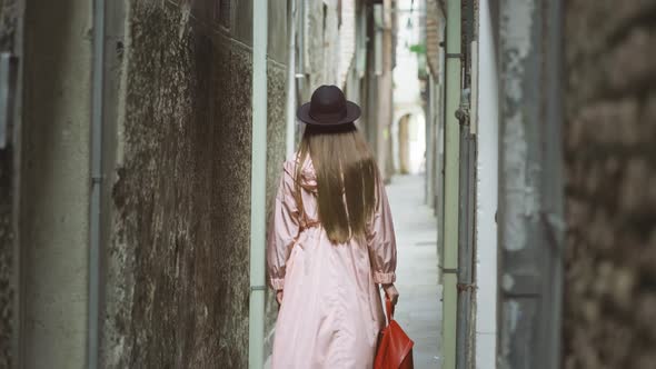 Woman with Long Hair Walks on Narrow Street in Venice