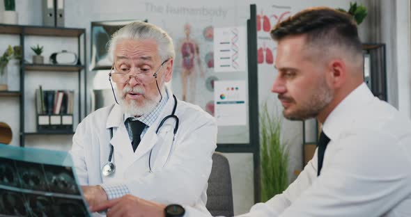 Man Visitingmedical Office Where Responsible Experienced Senior Grey-Haired Doctor