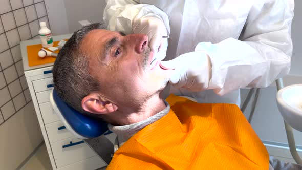 Man Undergoing Dental Cleaning at the Dentist