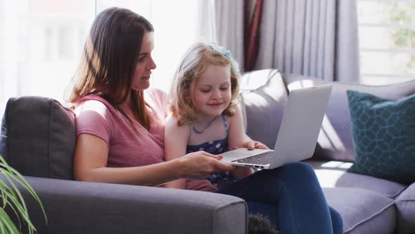Caucasian mother and daughter having fun using laptop
