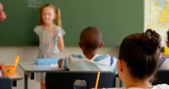 School kids applauding schoolgirl at front of class in classroom at school 4k