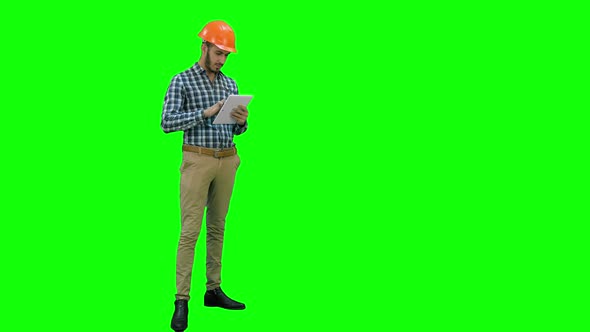 Engineer Using a Wireless Tablet To Check Construction Project on a Green Screen, Chroma Key