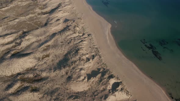 Video over beautiful wild beach with sand dunes and clear waters