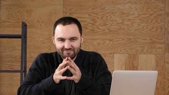 Thinking Man in Office Looking in Camera