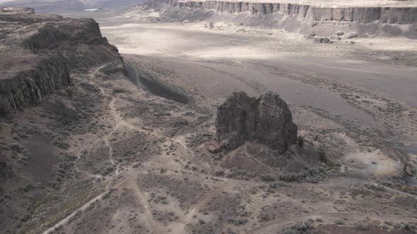 Slow aerial orbit of a large rock formation revealing Frenchman's Coulee State Park, WA