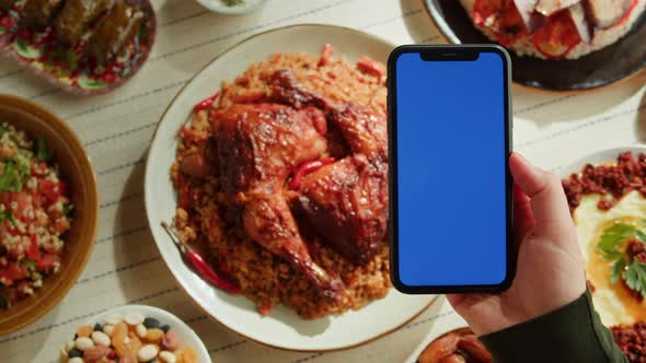 Kabsa Hummus Maqluba Maqluba Tabbouleh Closeup Smartphone with Blue Chroma Key Screen Middle Eastern