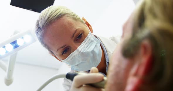 Dentist examining a patient with tools