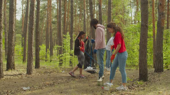 Caring Diverse People Picking Up Litter in Woodland