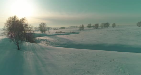 Aerial View of Cold Winter Landscape Arctic Field Trees Covered with Frost Snow Ice River and Sun