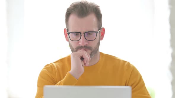 Portrait of Man Thinking While Using Laptop