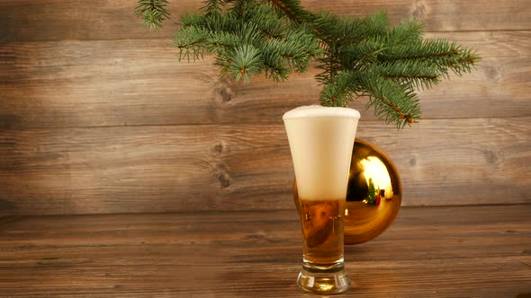 Beer Is Pouring Into A Glass Against The Background Of A Mirror Christmas Ball.