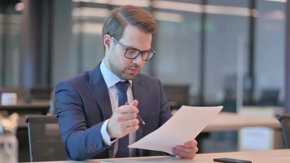 Businessman Reading Documents in Office