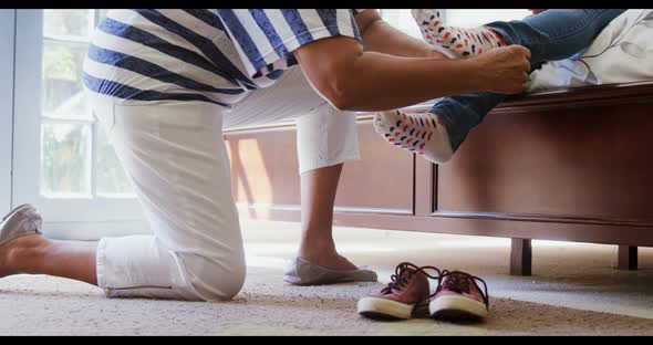 Grandmother helping granddaughter to wear shoes in bedroom 4k