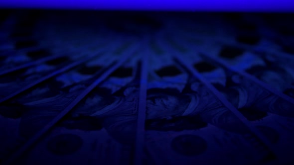 Hundred Dollar Bills Under Ultraviolet Light Slowly Rotates in a Circle