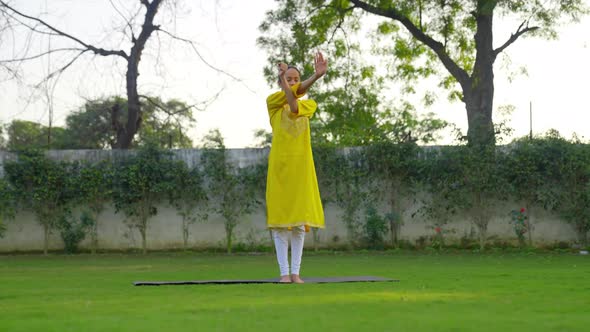 Indian woman doing Hand exercise or yoga in a park