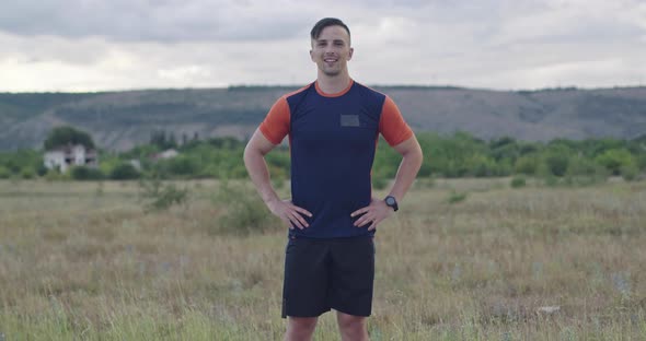 Portrait the Determined Guy Standing on the Road in Sports Clothes and Preparing for Morning Run