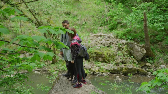 Couple with a dog standing next to a river