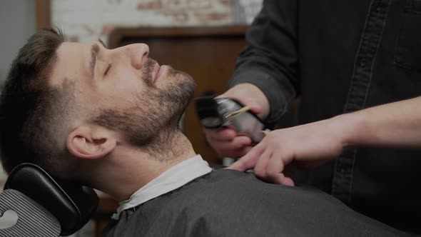 Young Hipster Caucasian Man During Beard Grooming in Modern Barber Shop