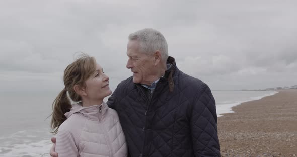 Portrait of active Senior adult couple day in life, on beach together in autumn