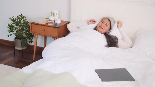 Asian woman waking up and stretching