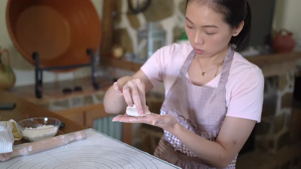 Female cook stuffing dough with meat