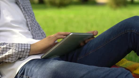 Male Freelancer Working on Tablet in Summer Park, Student Searching Job Online