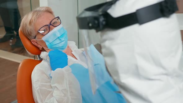 Dentist in Coverall Preparing Patient for Dental Surgery