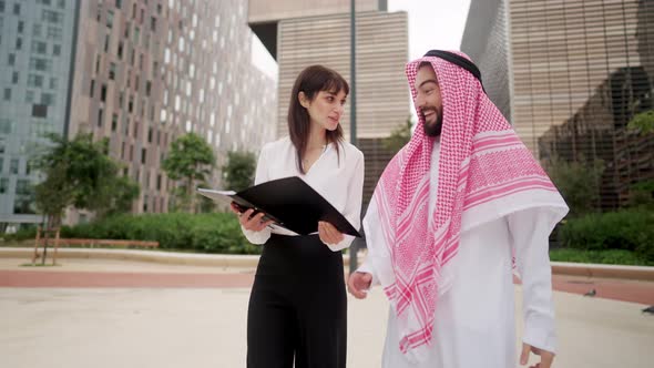 Young European Business Woman Making Successful Deal with Arab Man Client at Outdoor Meeting