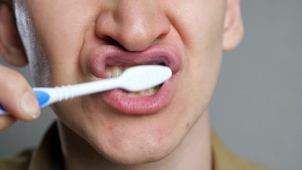 Close Up Head Shot Young Man Brushing Teeth in Bathroom