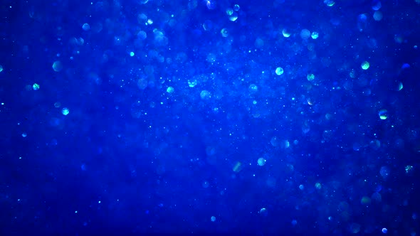 Abstract blue sparkly particle background with bokeh light and shiny frozen crystals in water LOOP.