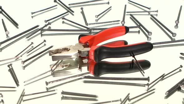 Gray and Red Pliers on White Among Nails, Reflection, Rotation