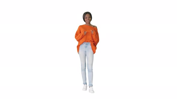 Cheerful African American Woman Wearing Bright Sweater and Jeans Talking To the Camera on White