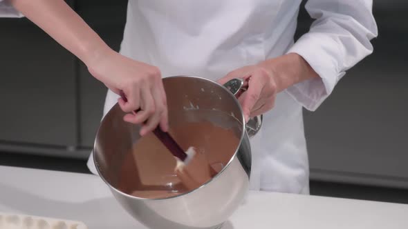 Pastry Chef Kneads the Chocolate Mousse for the Cake