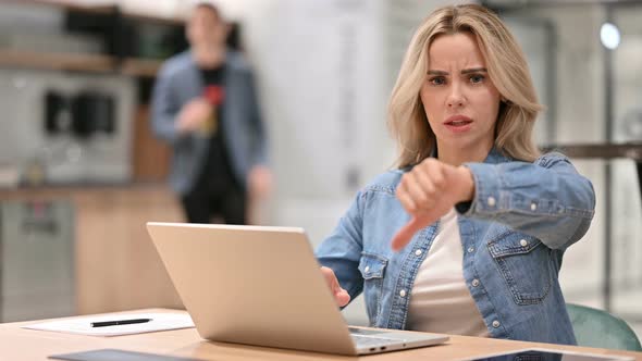 Young Casual Woman with Laptop Showing Thumbs Down 