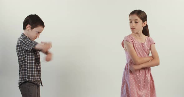 Brother and sister arguing and fighting on a white studio background