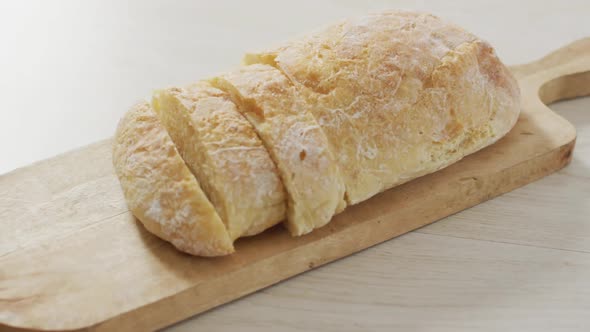 Video of bread on chopping wooden board on wooden worktop