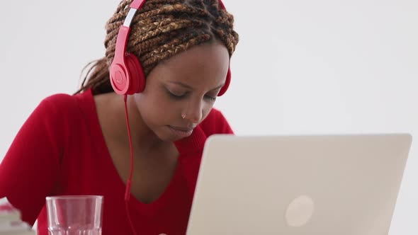 Young African American Woman is Working with Laptop While Sitting at Table in Apartment Room Spbi