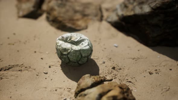 Old Football Ball on the Sand Beach