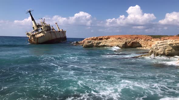 The sea waves beat against the abandoned merchant ship in the Cyprus. View of the crystal clear sea,